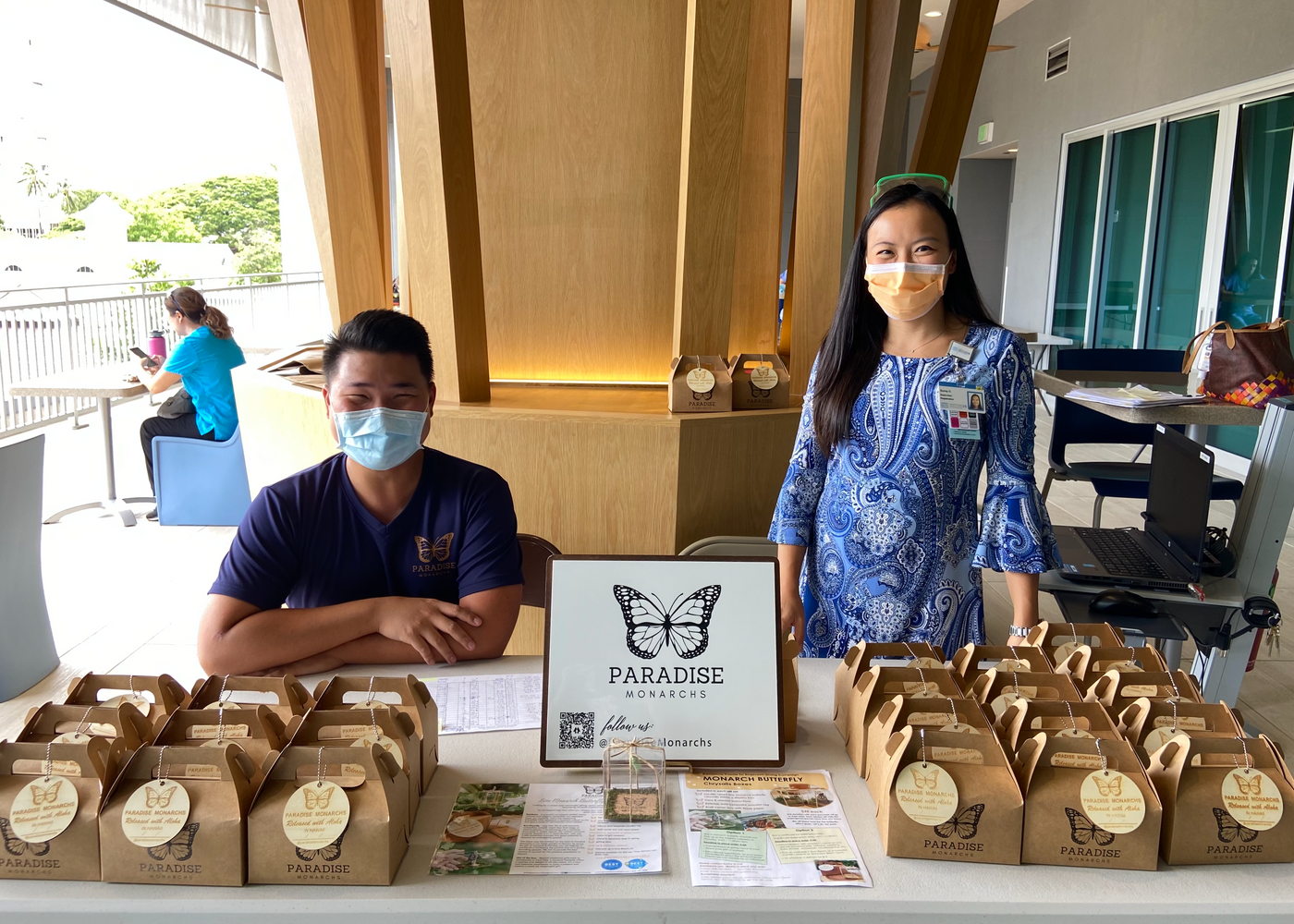 Owner Henry with staff providing a company corporate business gifting experience allowing attendees to pick up their live monarch butterfly chrysalis box in Honolulu Hawaii