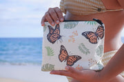 Monarch butterfly with monstera & milkweed leaves plants with monarch butterflies custom design. Splash proof waterproof tyvek pouch bag on a sandy beach in hawaii merch