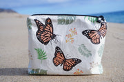 Monarch butterfly with monstera & milkweed leaves plants with monarch butterflies custom design. Splash proof waterproof tyvek pouch bag on a sandy beach in hawaii merch
